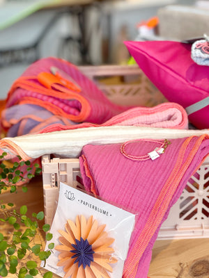 Klappkiste gefüllt mit rosa- und pinkfarbenen Dreieckstüchern
