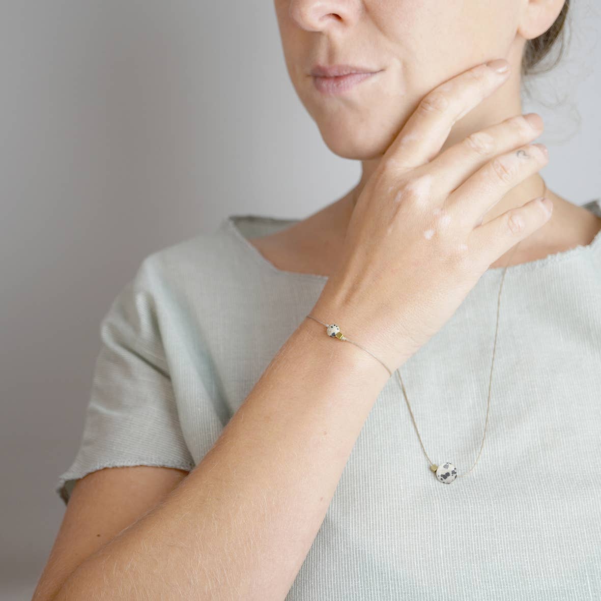 Detailansicht einer Kette: Dalmatiner Jaspis mit Messingelement an gewachstem Band 