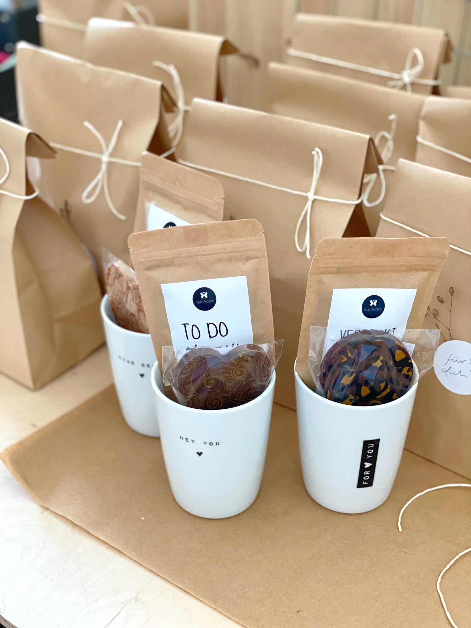 Geschenktüten aus Kraftpapier, natürlich dekoriert, darauf ein Glas Gewürznüsse, eine Tüte mit Gewürzmischung und ein Schokoladen Lolli im Zebramuster. Conceptstore Stadtrandstil