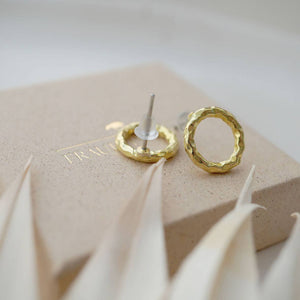 Ohrstecker rund, strikturierte Oberfläche, goldfarben auf Schmuckschachtel