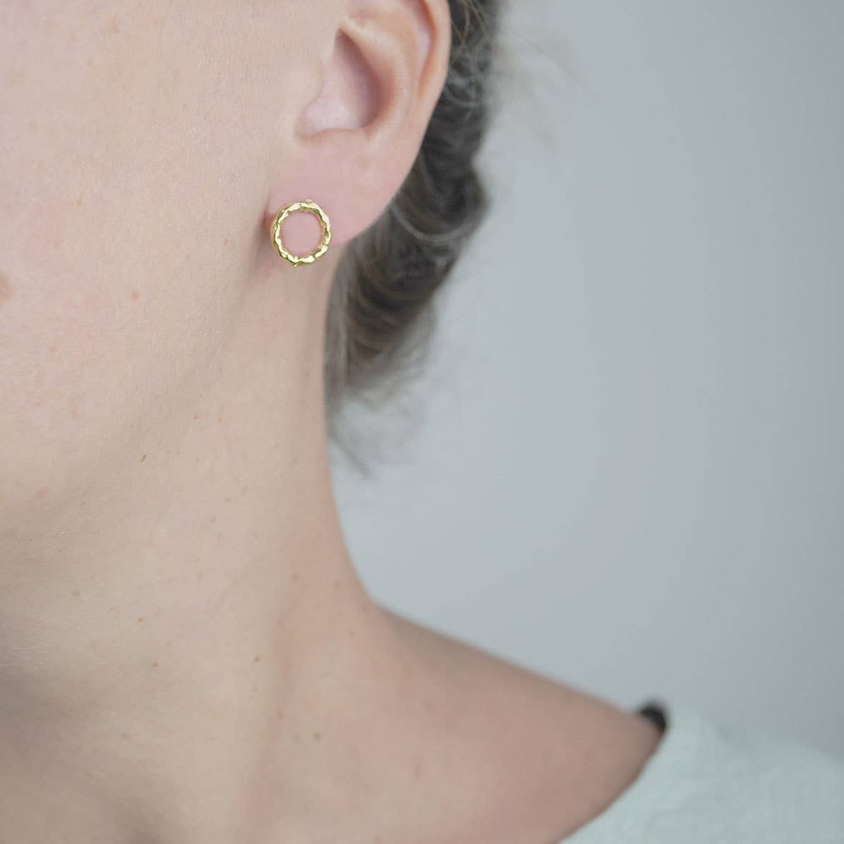 Ohrstecker rund, strikturierte Oberfläche, goldfarben auf Schmuckschachtel