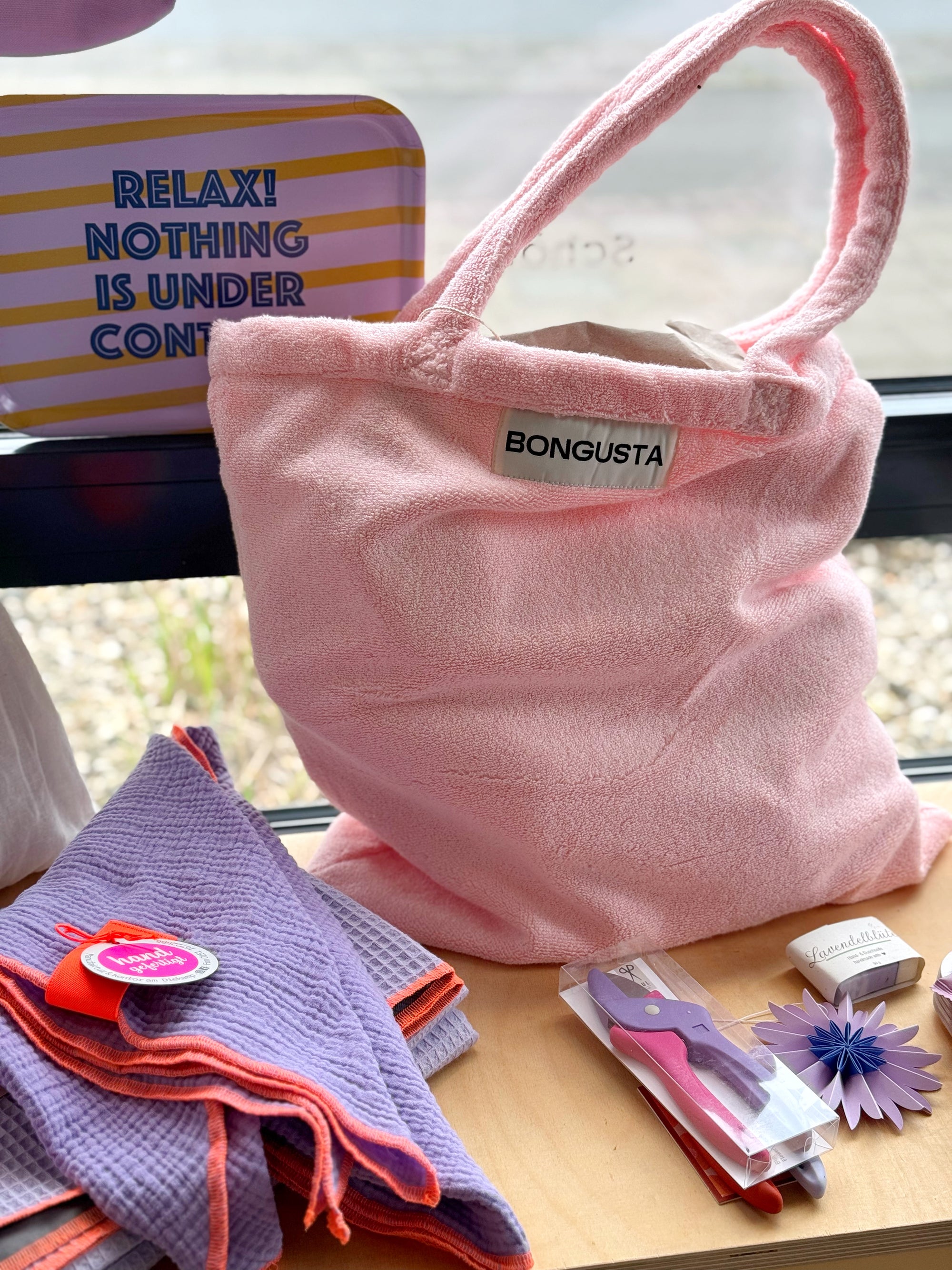 grün gestreifter shopper und handtücher auf gartenstuhl