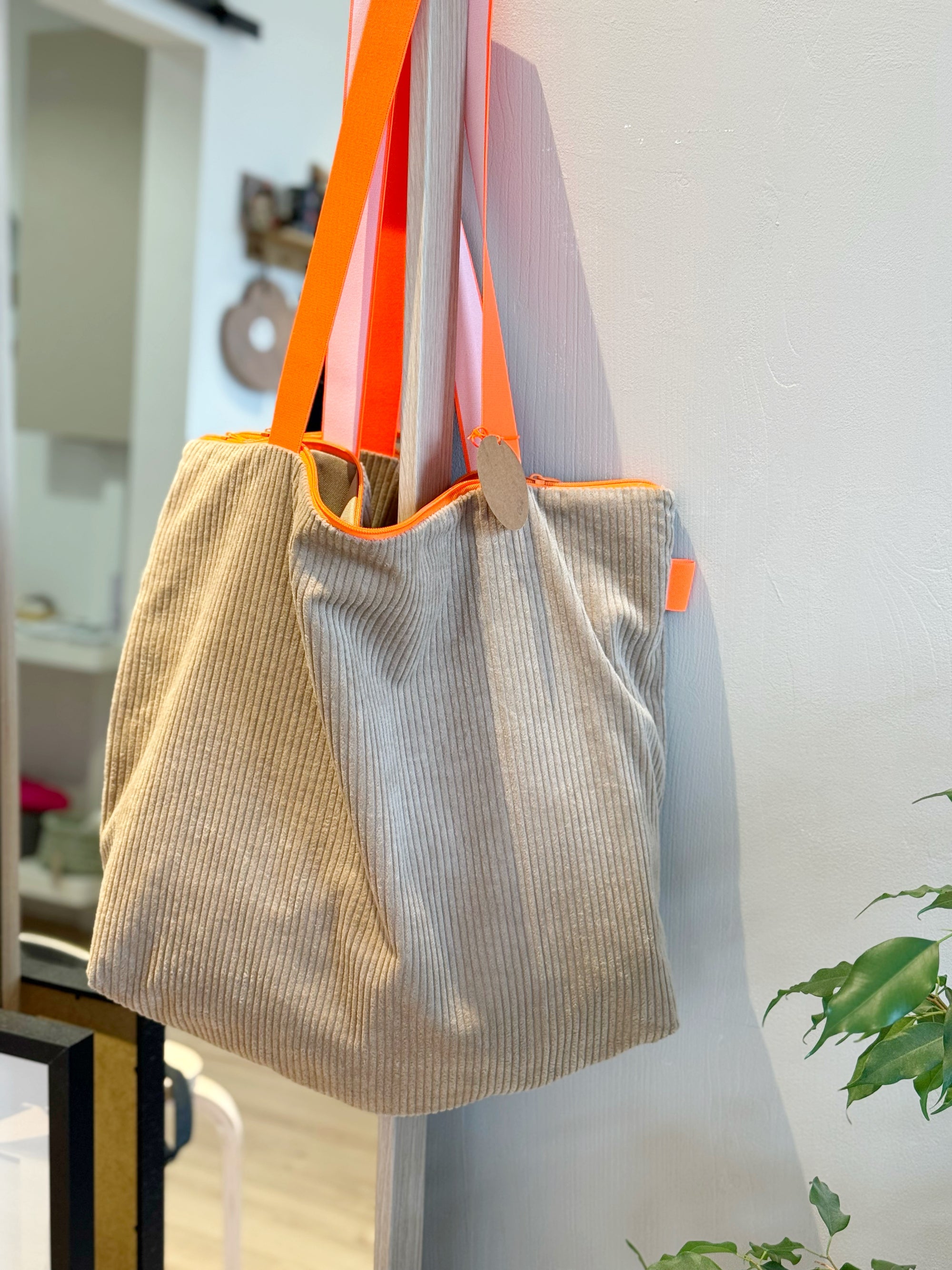 Sandfarbener Shopper aus Cord mit neon orangenem Gurt