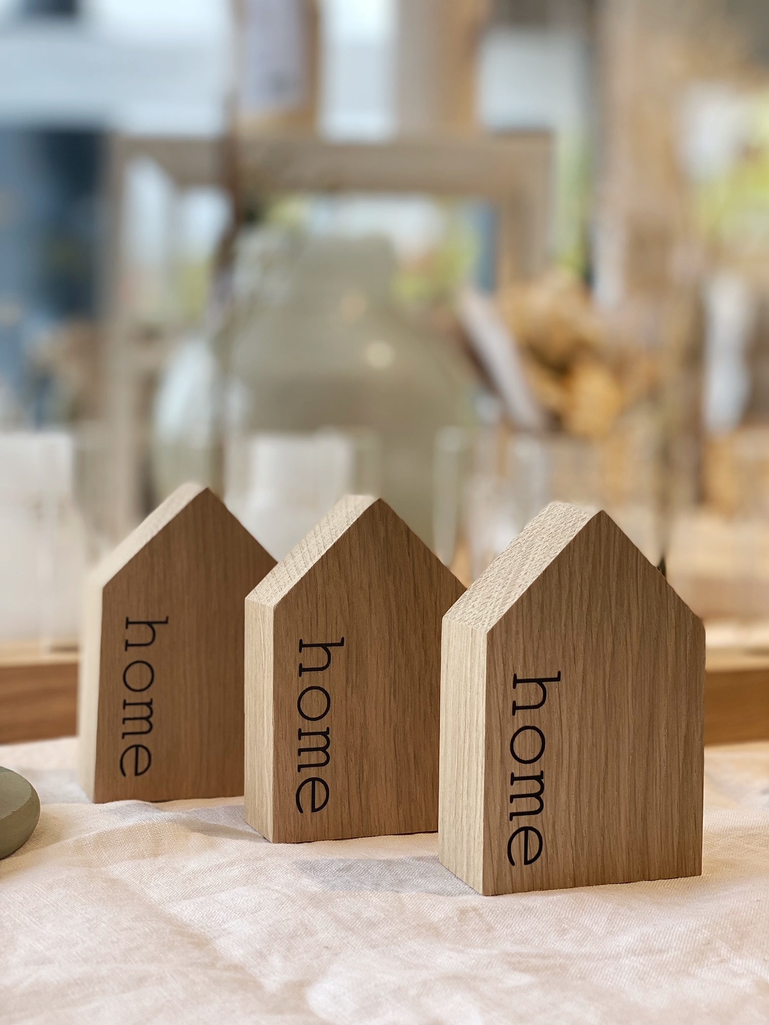 Dekohaus aus Eiche mit aufgedrucktem "home" zwischen anderen Holzhäusern von tadtrand Stil handmade