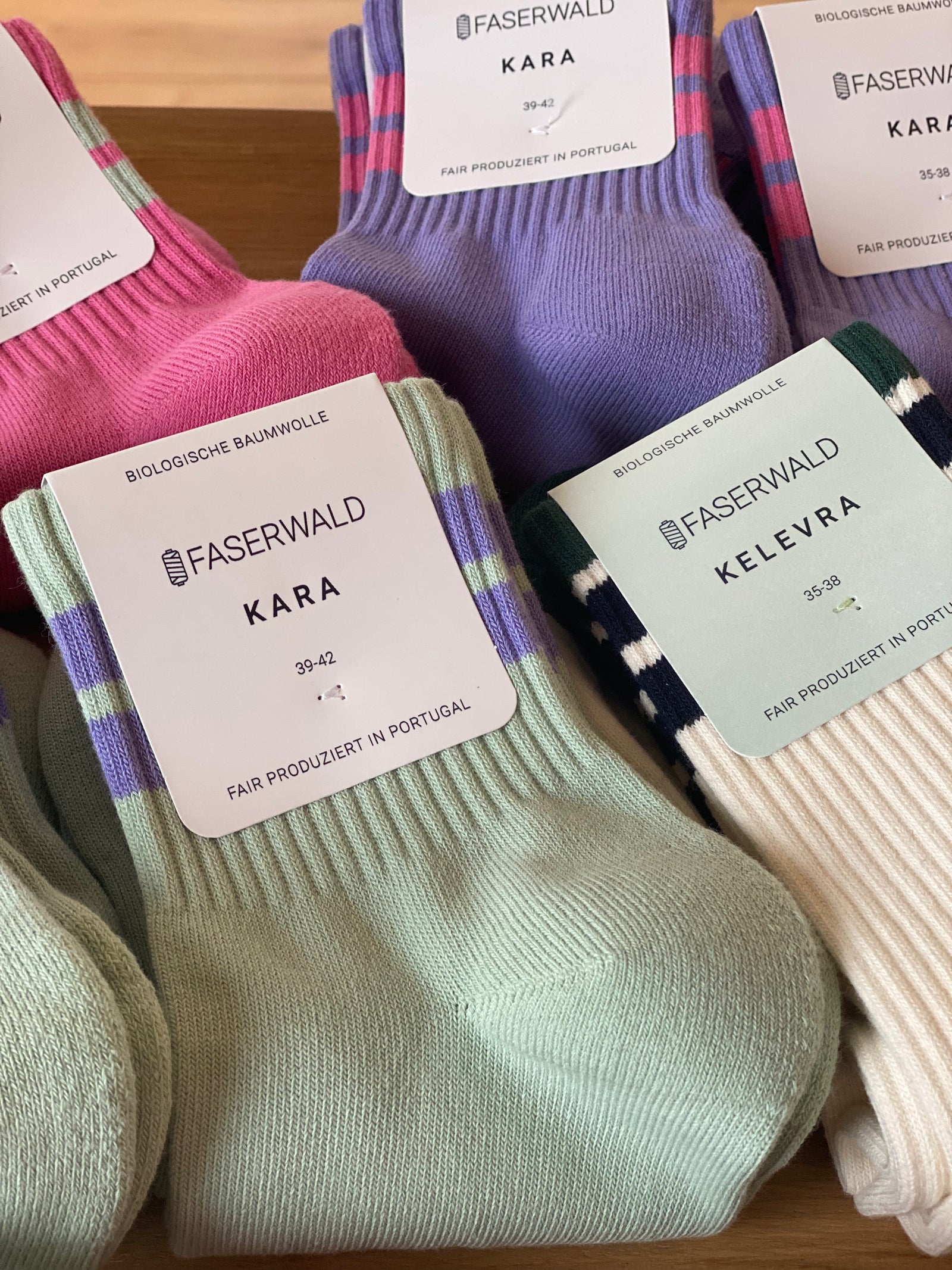 Bunte Socken in rosa, lila und natur in einem Korb. Bio Baumwolle,
faserwald bei Stadtrandstil, Retro 
