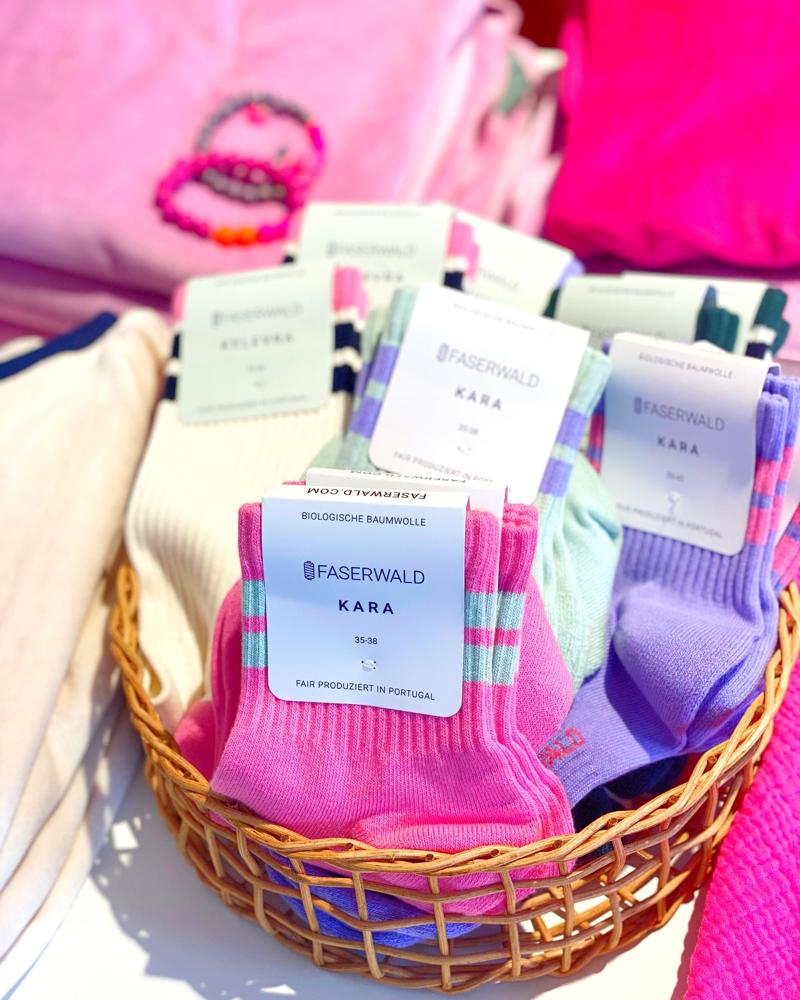 Bunte Socken in rosa, lila und natur in einem Korb. Bio Baumwolle,
faserwald bei Stadtrandstil, Retro 