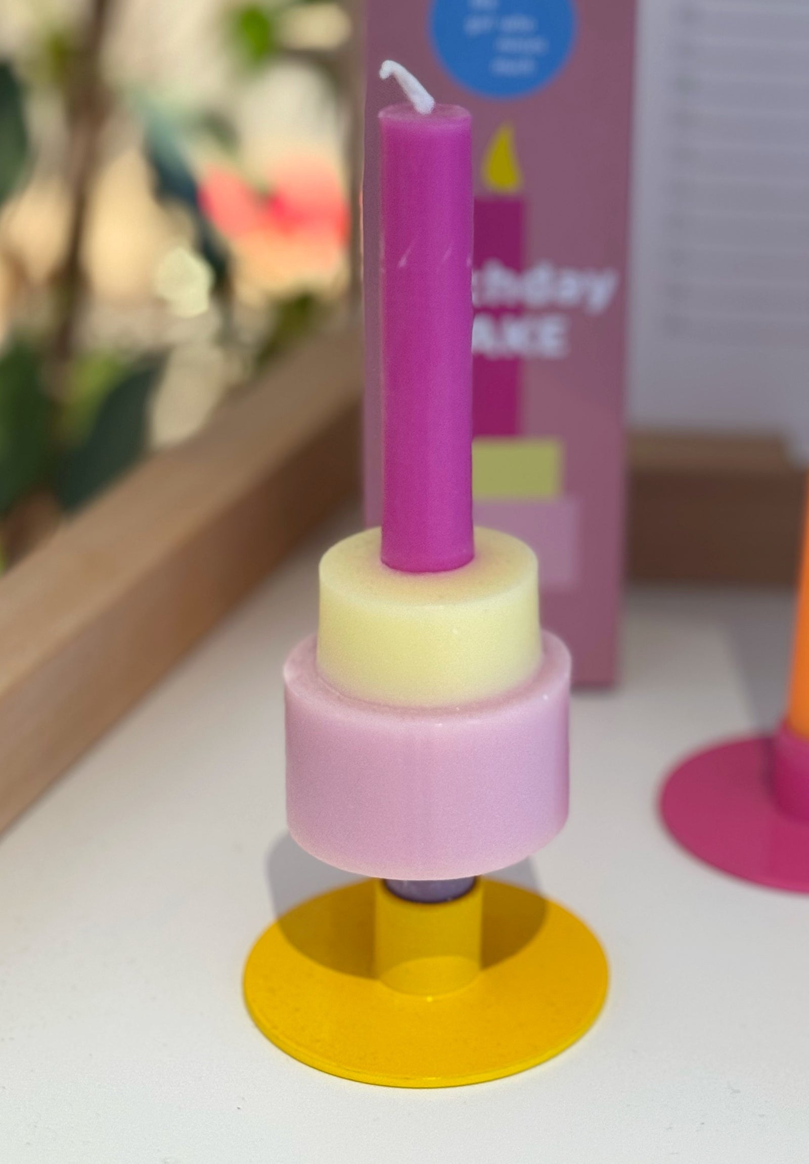 Rosa gelb Farben Kerze in form eines Geburtstagskuchens in gelbem Kerzenständer