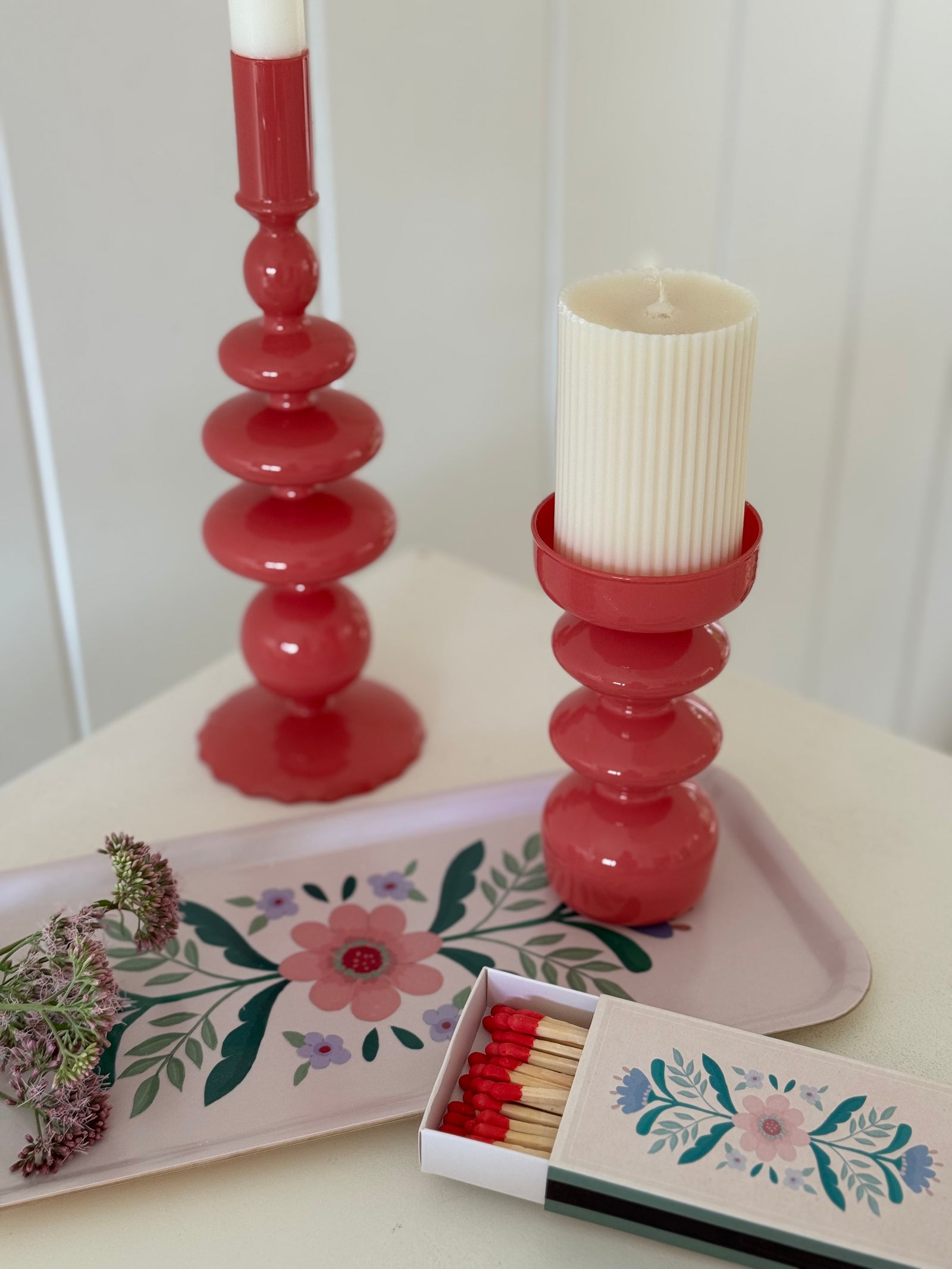 zwei glas kerzenhalter mit blumentablett auf küchentisch