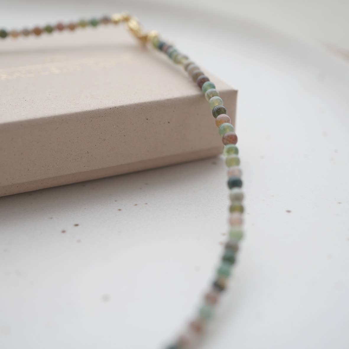 produktfoto kette pearl auf weißem teller