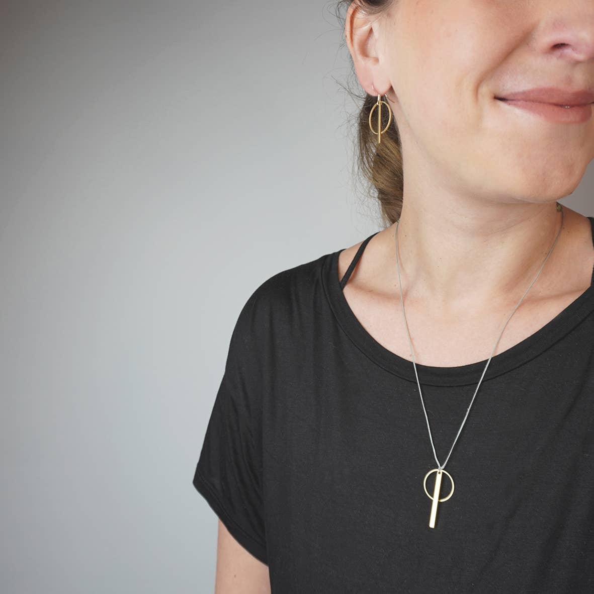 Detailaufnahme Kette: minimalistische Anhänger golfarben ein Ring und ein Rechteck an Band