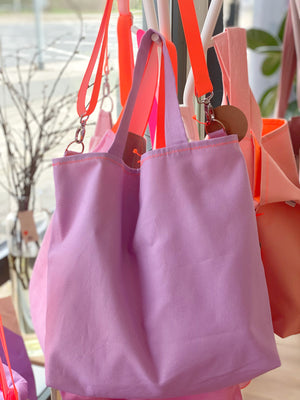 Fliederfarbenee Shopper mit Neongurt in orange, hängend