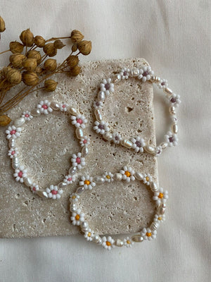 Steinplatte mit Trockenblumen und weißen Daisyarmbändern