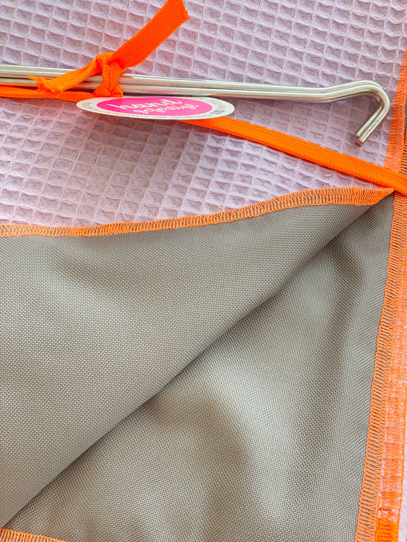 zusammengelegte Strandtücher in flieder und pink aus Waffelpikee mit zwei Heringen