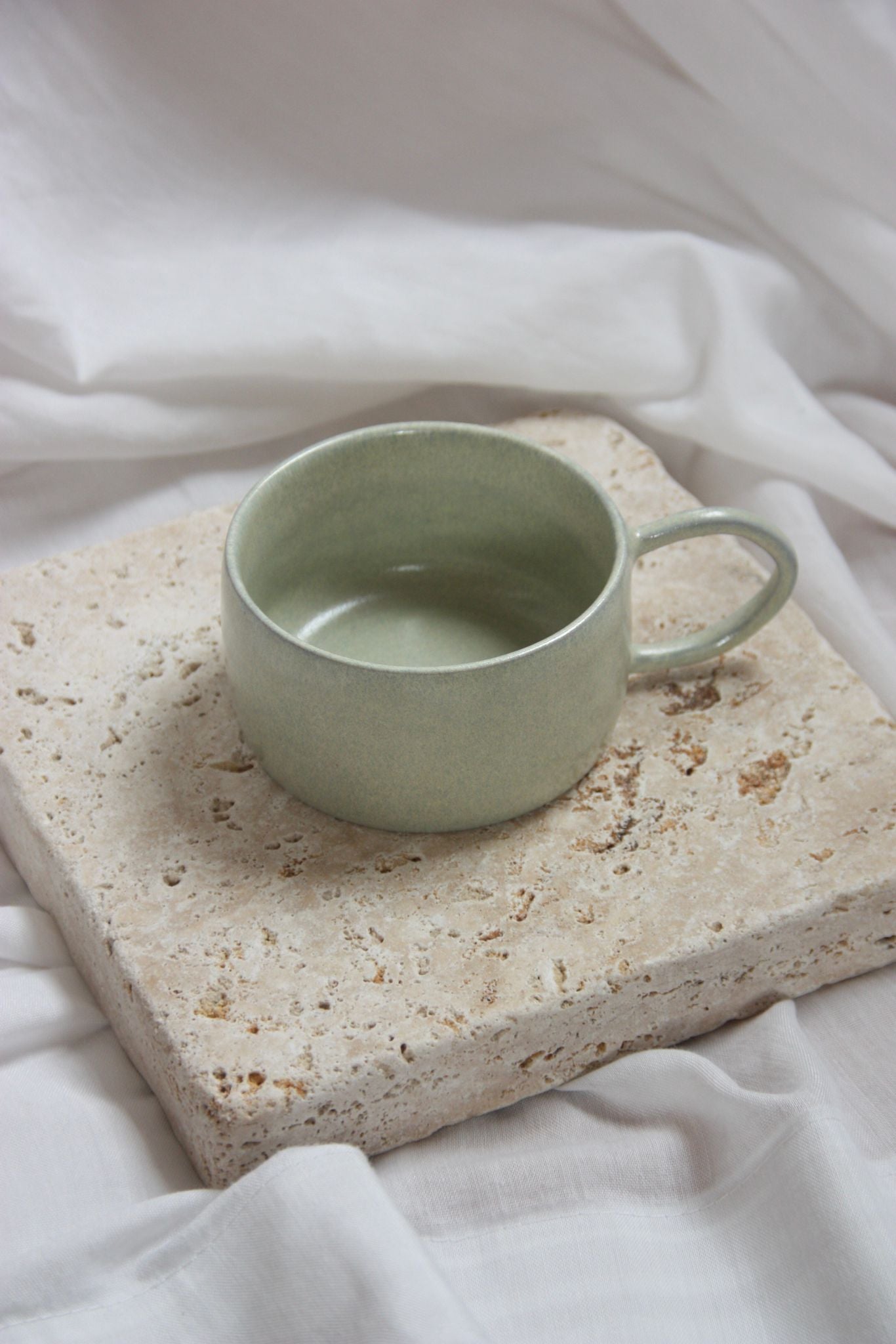 getöpferte tasse auf steinplatte