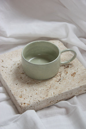 getöpferte tasse auf steinplatte
