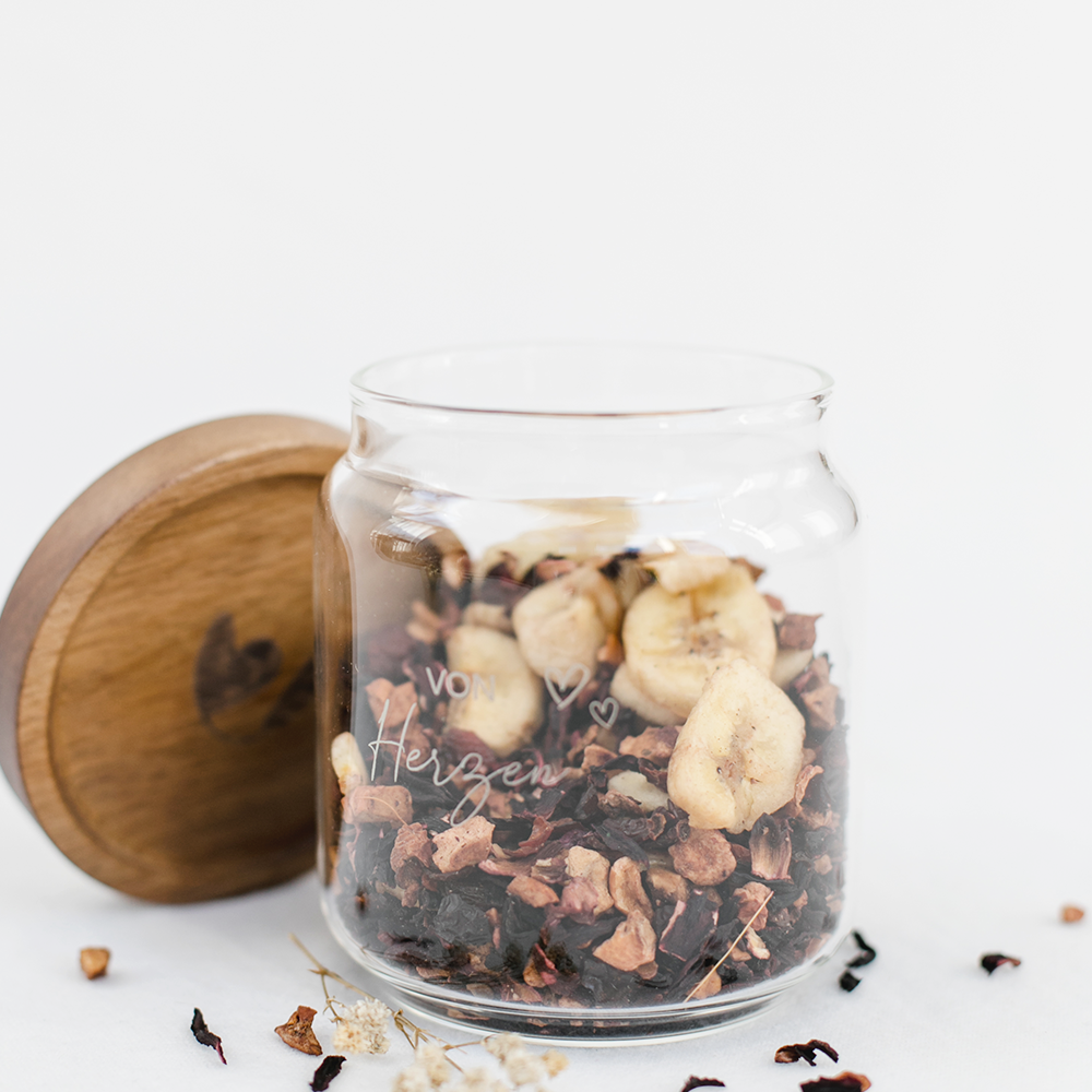 Mit Müsli gefülltes Vorratsglas mit dem Aufdruck von Herzen" und einem Holzdeckel