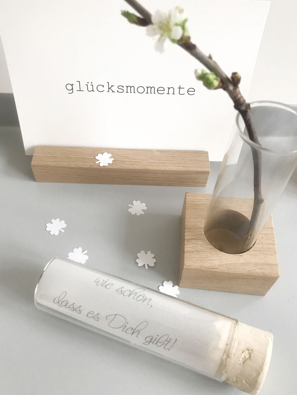 Inspiration : kleiner Fotohalter mit einer Karte "Glücksmomente", einer Vase und einem Reagenzglas mit einem eingelegten Transparentpapier "wie schön, dass es dich gibt".