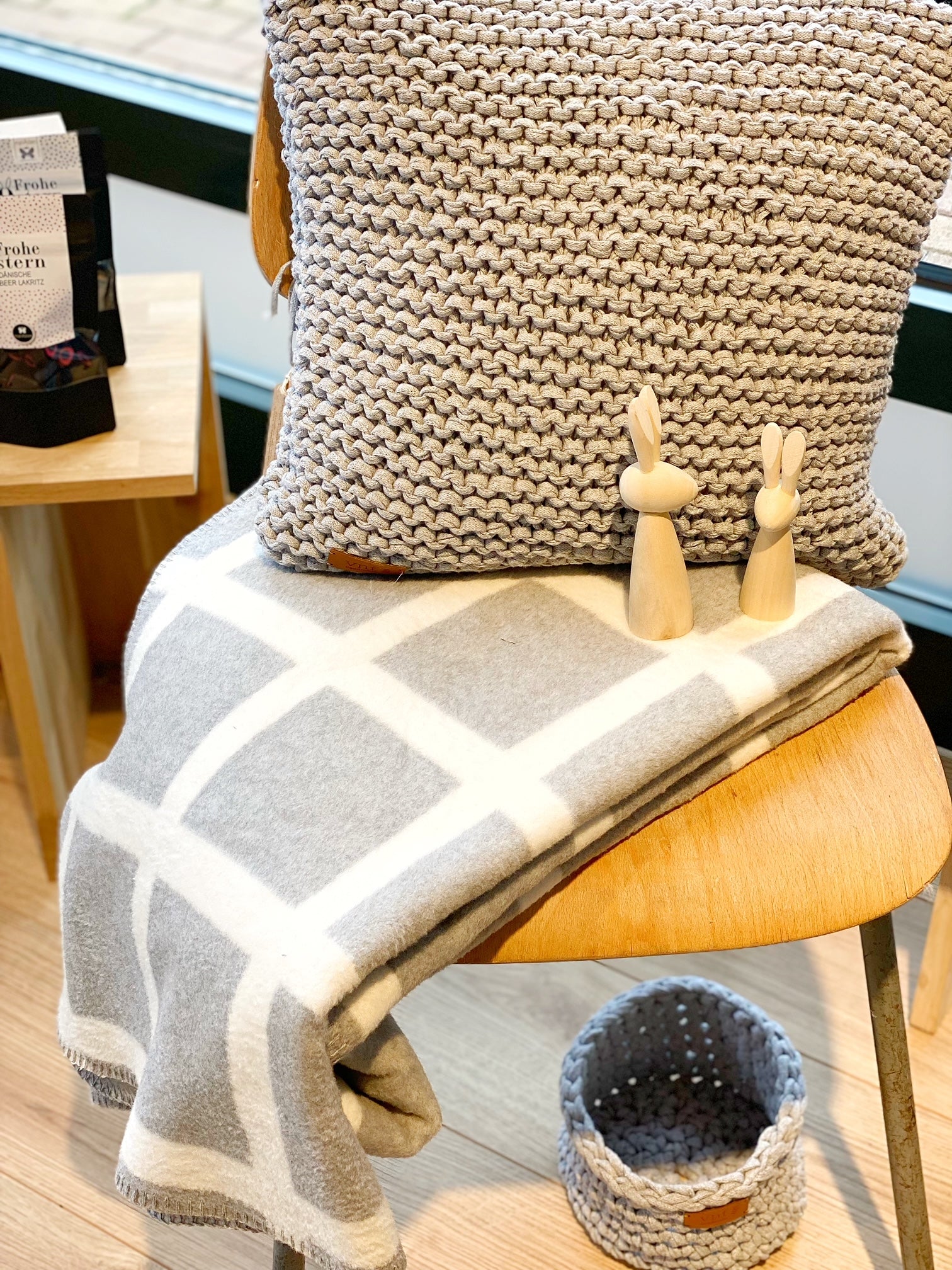 Stuhl mit einer grau-weiß karierten Baumwolldecke bo Riema zwei minimalistischen Hasen und einem grauen, handgestricktem Kissen von stadtrandstil handmade
