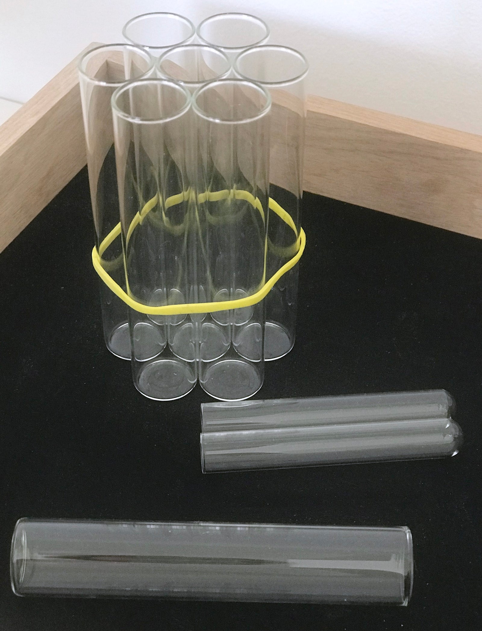 schwarzes Tabeltt mit nehreren Gasl Reagenzgläsern