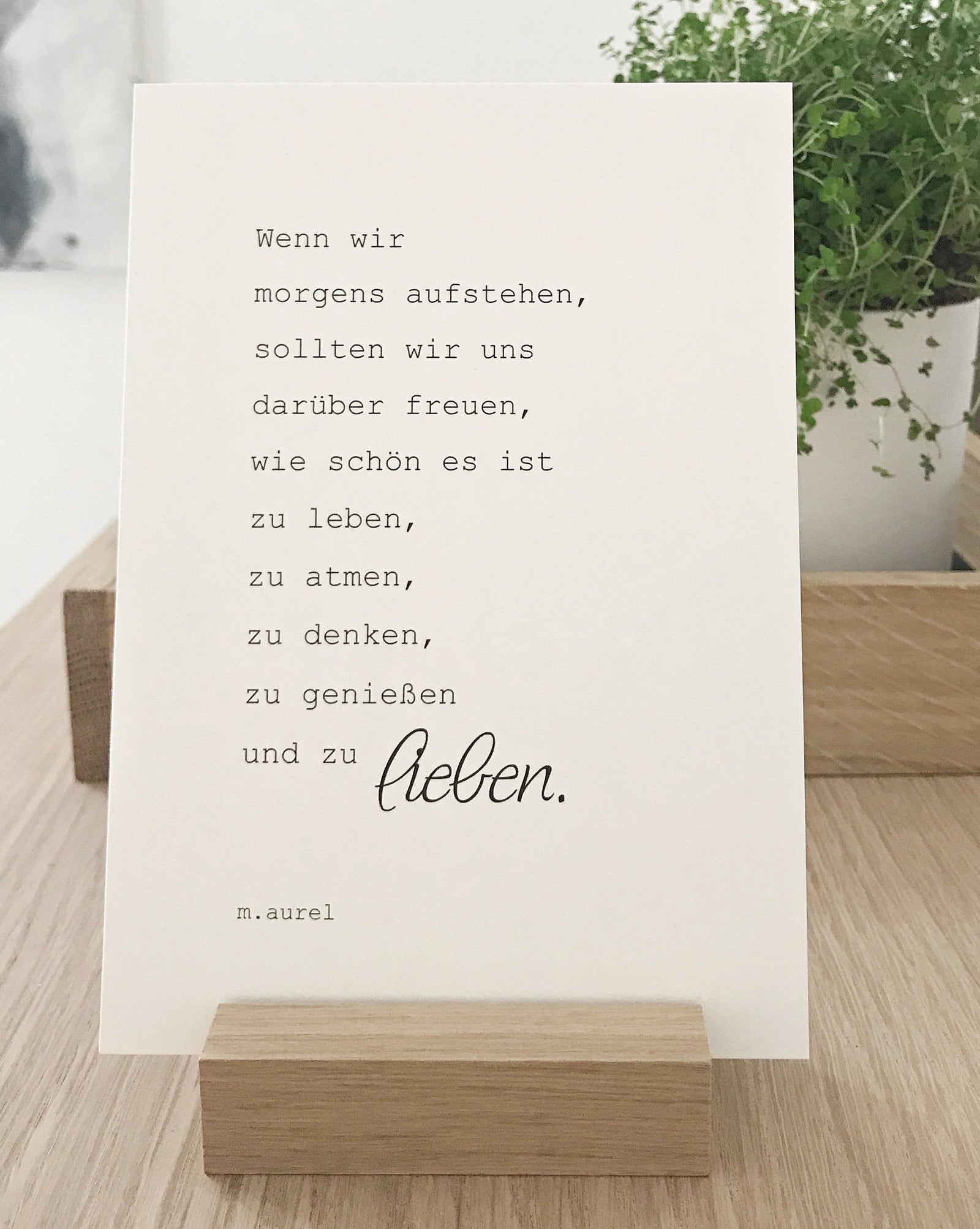 Postkarte mit einem Zitat von Aurel in einem Karte halter aus Holz