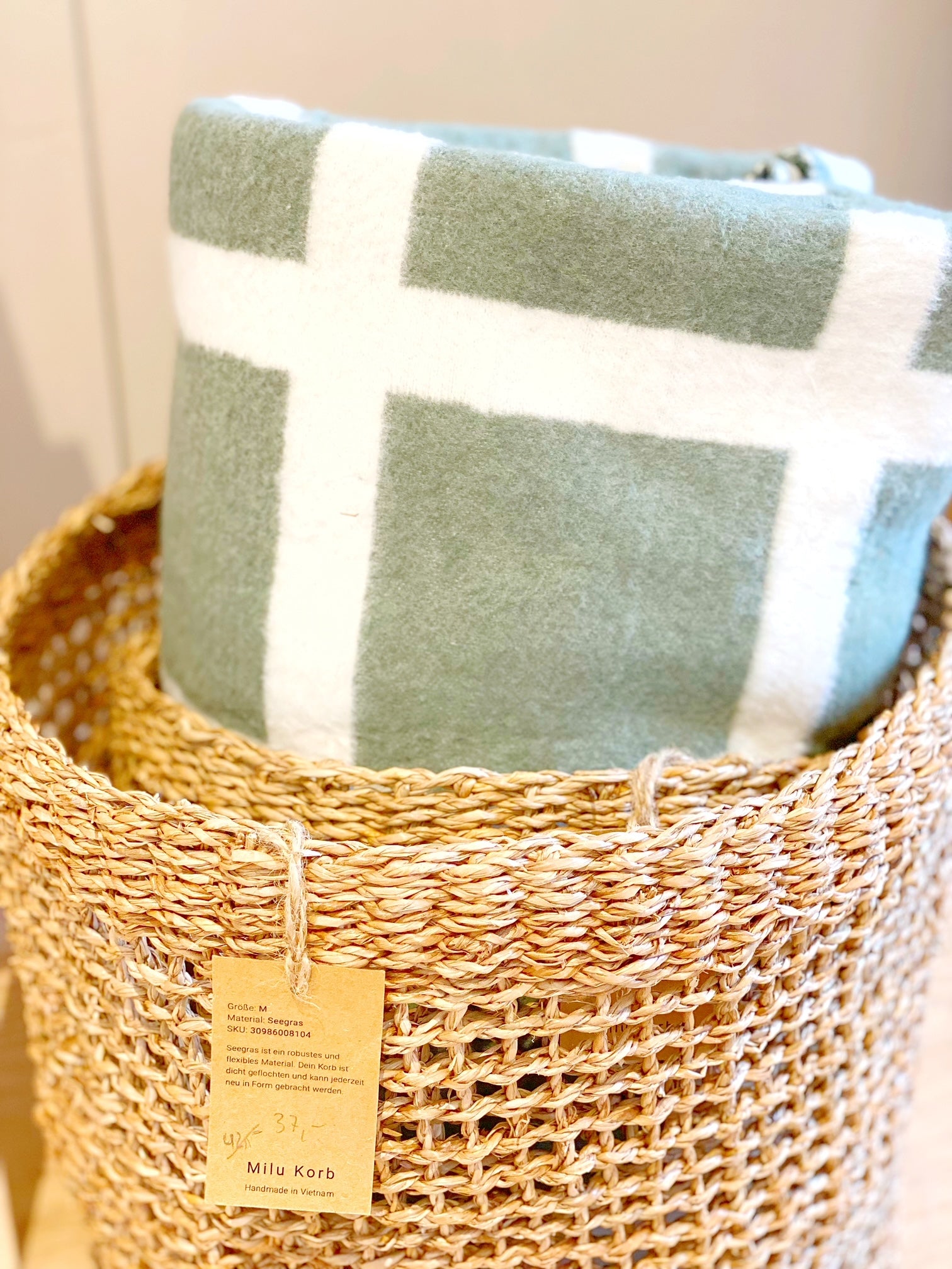 Stuhl mit einer grau-weiß karierten Baumwolldecke bo Riema zwei minimalistischen Hasen und einem grauen, handgestricktem Kissen von stadtrandstil handmade
