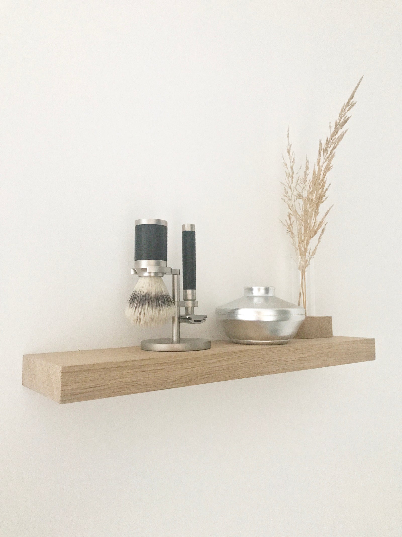 Regalbord aus Eiche, natürliche Dekoration im Bad mit Rasierpinsel, Rasierer, Seifenschale und Minivase mit getrocknetem Gras